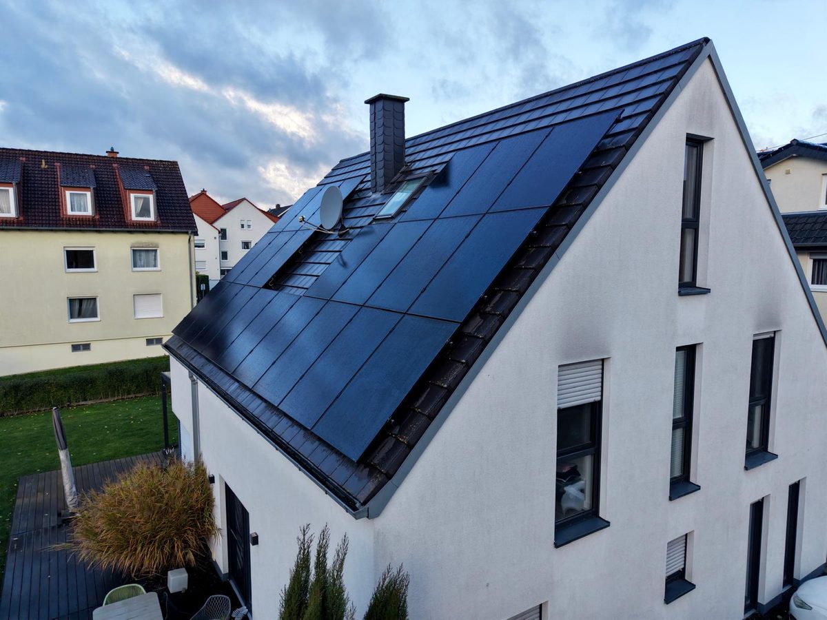 Weißes EFH mit vollflächiger PV-Anlage im Abendlicht